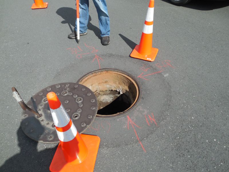 Opened Manhole Between Traffic Cones
